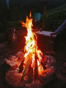 A warm, inviting campfire surrounded by rocks in a peaceful outdoor setting.